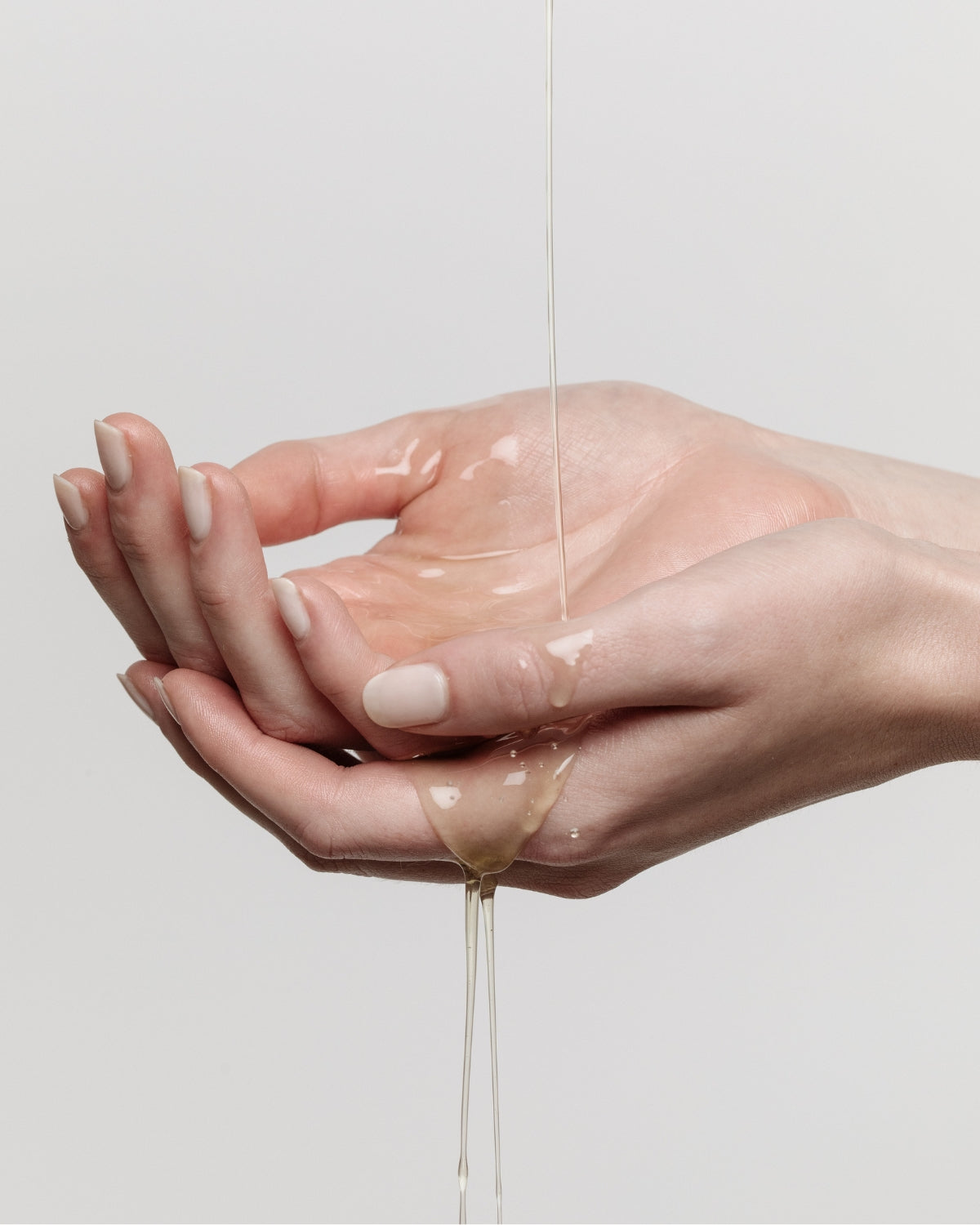 an-balm in liquid state melted over two hands 